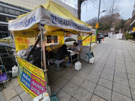 서울중앙지방법원 근처 정곡빌딩 동관 앞 인도에 위치한 한국사기예방국민회 천막. 김주연 대표와 농성 참가자가 자리에 앉아 있다. 사진=위즈경제