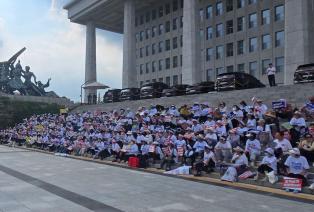 한국사기예방국민회 회원들이 서울 여의도 국회 본청 앞 계단에서 '조직사기특별법 제정' 조속한 입법을 요구하며 피켓을 들고 구호를 외치고있다.(사진=한사국)