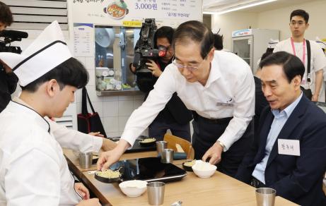 한덕수 국무총리가 7일 서울 종로구 청년밥상문간 슬로우점을 방문해 경계선지능 청년과 보호자들을 격려하고 식사를 서빙하고 있다. 사진=연합뉴스