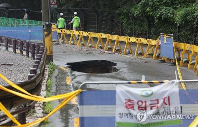 지난달 13일 집중호우로 인한 땅 꺼짐 현상이 발생한 서울 강북구 도선사 진입로에 시민들의 접근을 막는 펜스가 설치된 모습 (사진= 연합뉴스)