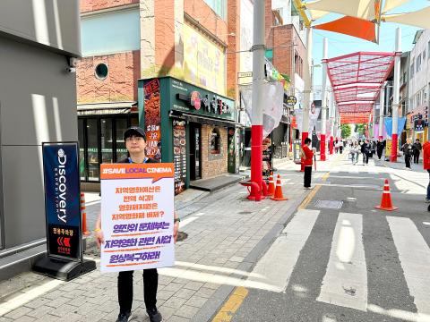 제25회 전주국제영화제에서 영진위 문체부는 지역영화 관련 사업 원상복구하라!'는 내용의 피켓을 들고 있는 백재호 한국독립영화협회 이사장 (출처=위즈경제)